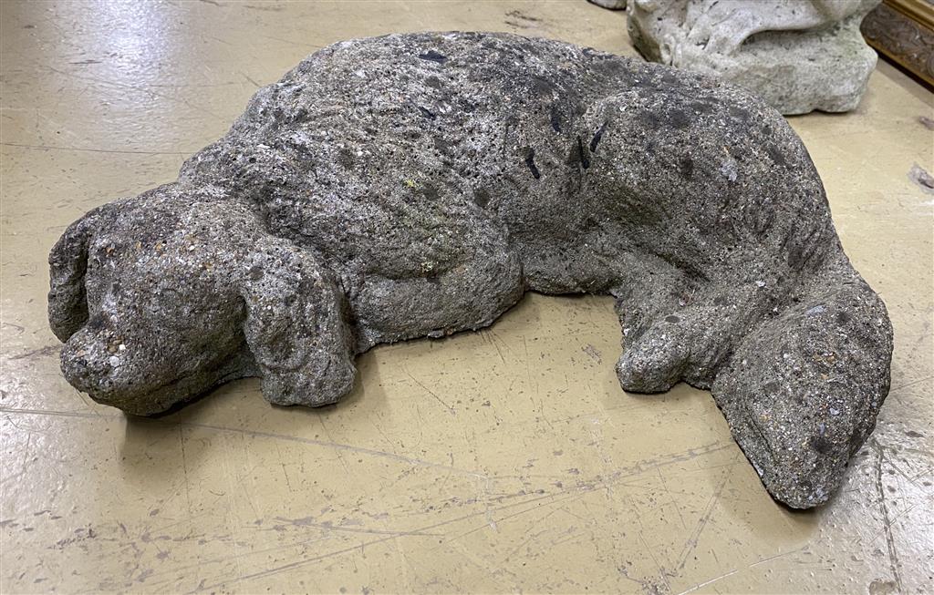 A reconstituted stone garden ornament of a sleeping spaniel, length 50cm
